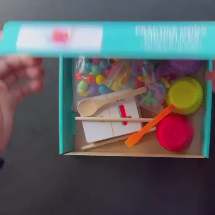 Unboxing the wooden number cognitive operation and bead matching game for kids. The video shows a close-up of the contents of the game box, including colorful plastic beads, wooden number blocks, and various tools such as spoons and small bowls. This educational game helps children learn basic math skills by matching the beads to the corresponding numbers on the cards. It also includes visual cues for number recognition and simple addition, subtraction, and multiplication. Perfect for developing motor skill