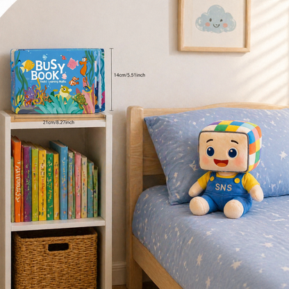 Toddler using a "Busy Book" for interactive learning, with a colorful bookshelf full of educational books nearby. The child is accompanied by a friendly plush toy, enhancing early literacy and engagement in a cozy, inviting room setting.